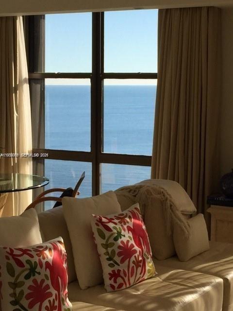 A living room features a beige sofa with patterned pillows and a large ocean-view window — 1121 Crandon Blvd # F1107, Key Biscayne FL 33149, KEY BISCAYNE, FL
