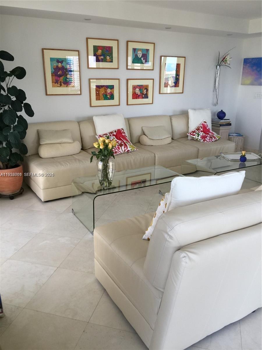 A living room features a beige sectional sofa, glass coffee tables, and framed wall art — 1121 Crandon Blvd # F1107, Key Biscayne FL 33149, KEY BISCAYNE, FL