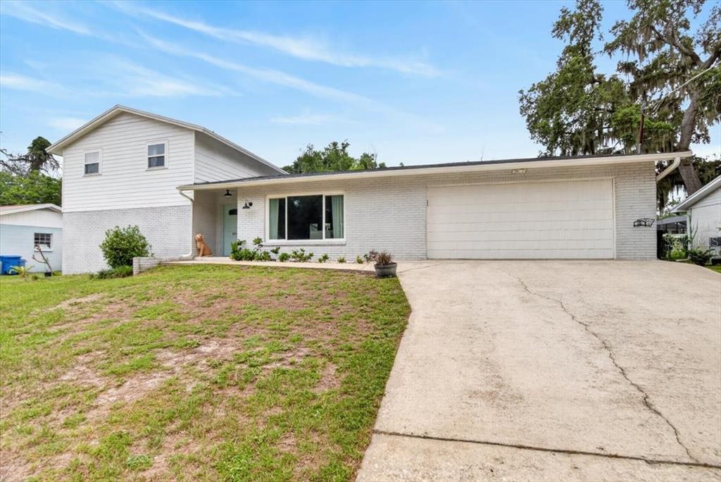 A two-story house with a white brick exterior, a two-car garage, and a concrete driveway — 115 W BRENTRIDGE DRIVE, BRANDON, FL