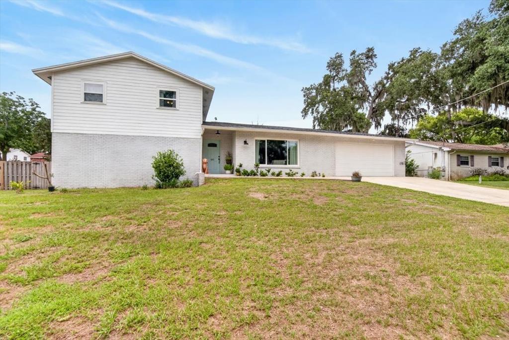 A two-story house with white siding, a brick lower level, and an attached garage — 115 W BRENTRIDGE DRIVE, BRANDON, FL