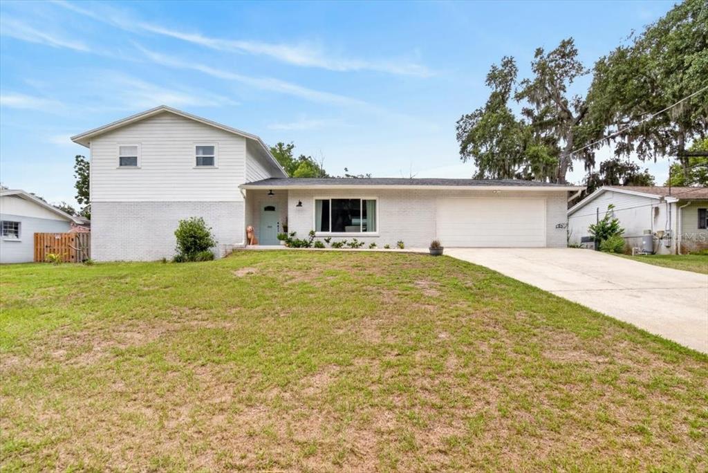 A two-story house with white siding and brick, a front lawn, and an attached garage — 115 W BRENTRIDGE DRIVE, BRANDON, FL