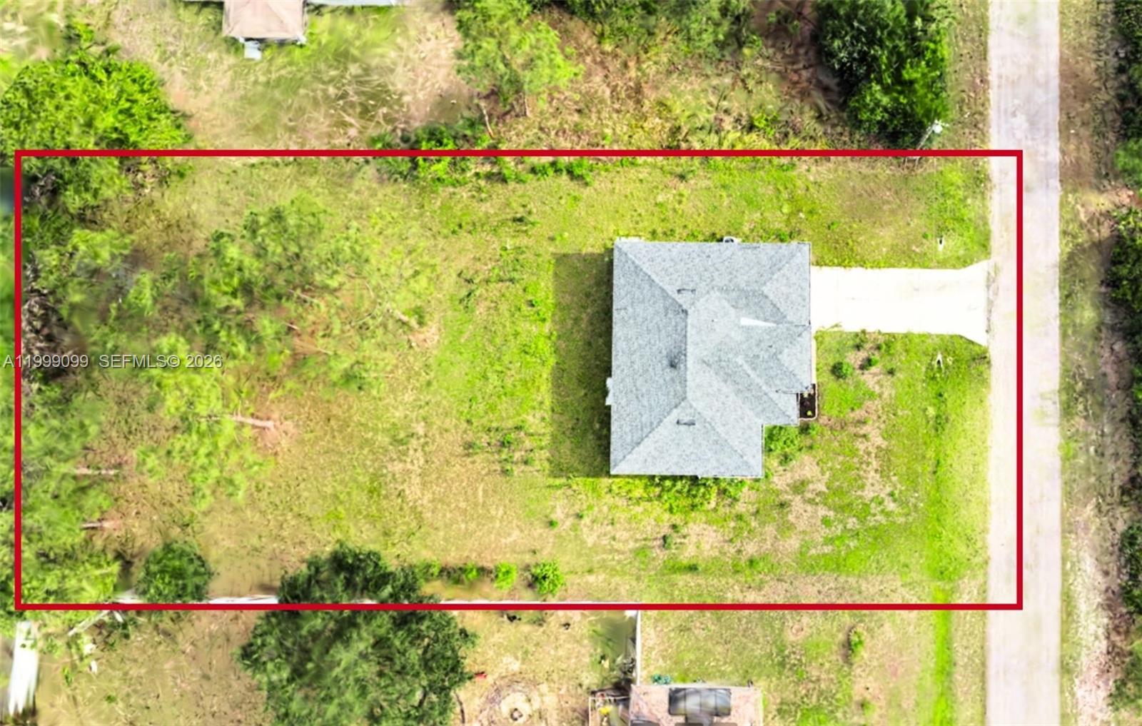 An aerial view shows a house with a gray roof centered on a large lot — 902 MAGNOLIA AVE, Lehigh Acres FL 33972, LEHIGH ACRES, FL