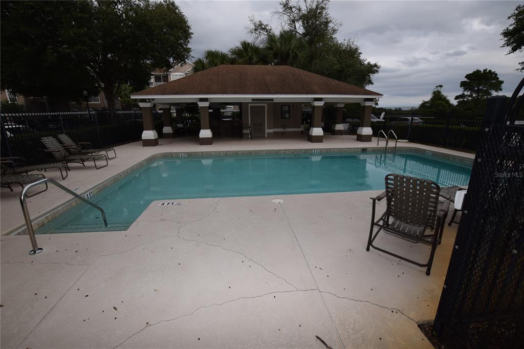 An outdoor swimming pool with a covered pavilion and lounge chairs on a concrete deck — 7109 YACHT BASIN AVENUE UNIT 435, ORLANDO, FL