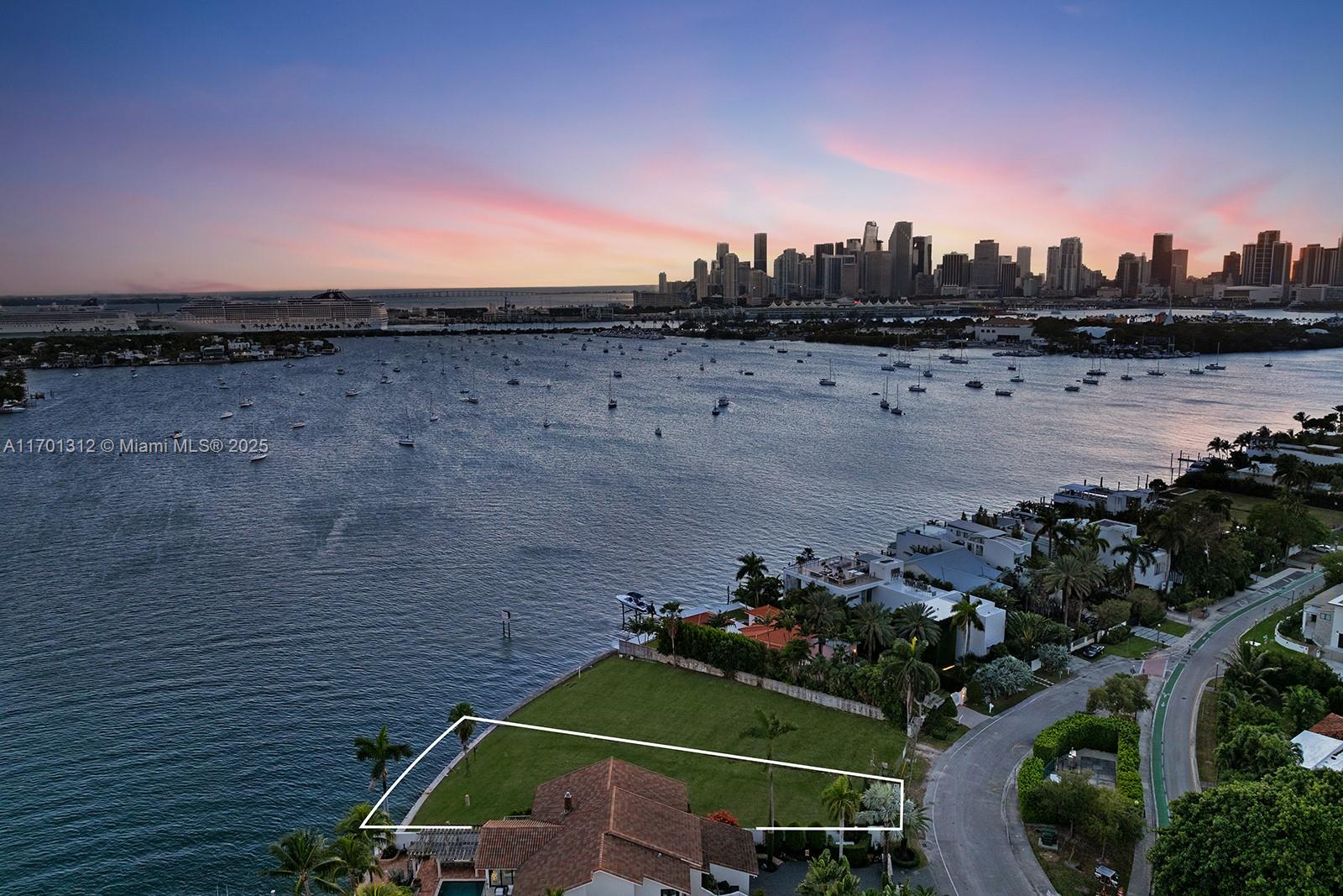 An aerial view shows a waterfront property with a large grassy yard and house — 1386 S Venetian Way, Miami FL 33139, MIAMI, FL