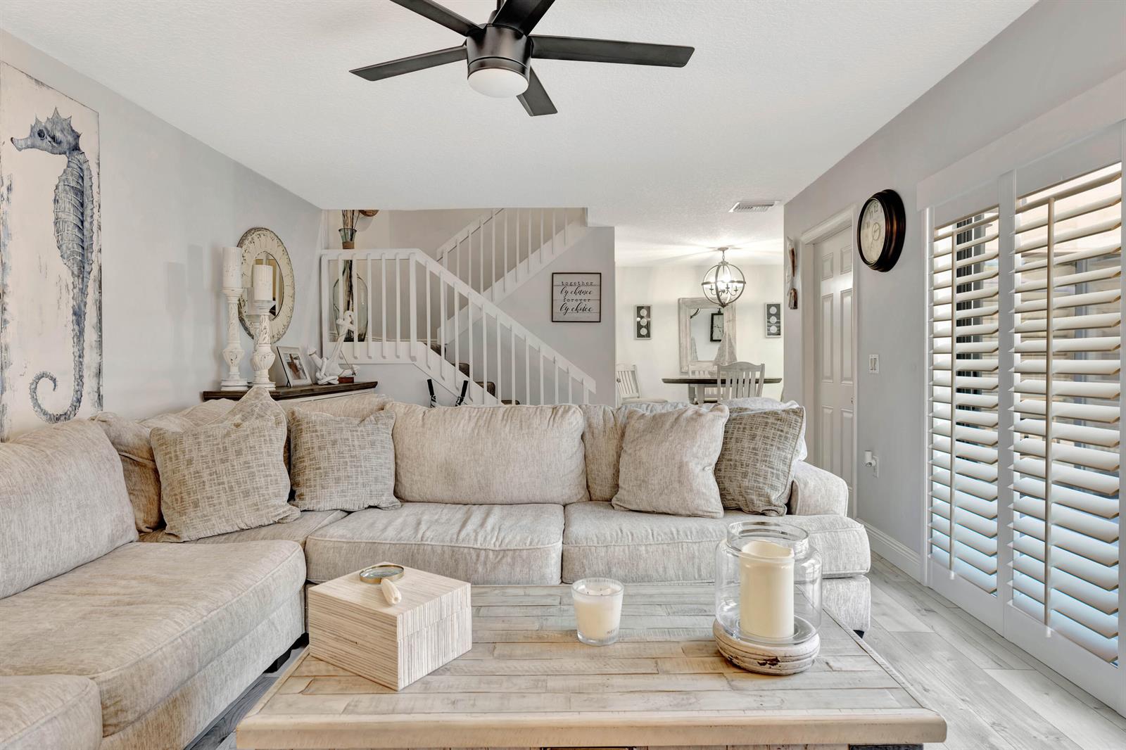 A living room features a large sectional sofa, a wooden coffee table, and a staircase — 1209 12th Court, Jupiter FL 33477, JUPITER, FL