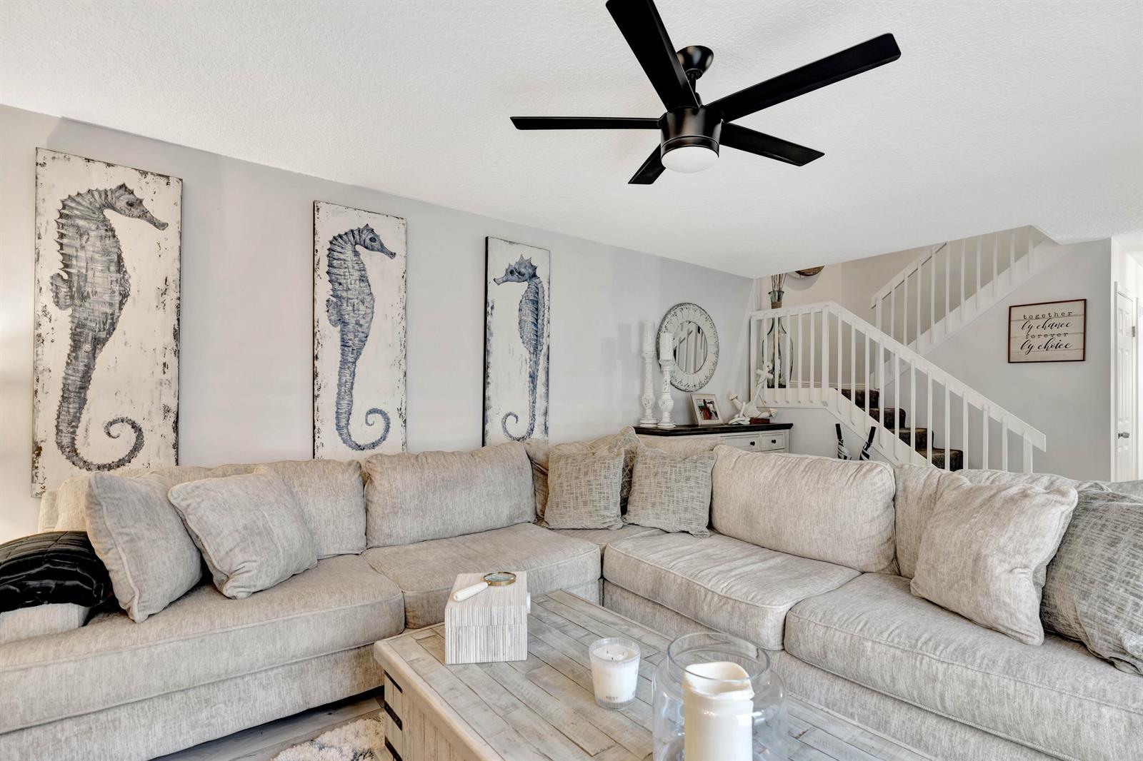 A living room features a large sectional sofa, three seahorse wall prints, and a ceiling fan — 1209 12th Court, Jupiter FL 33477, JUPITER, FL