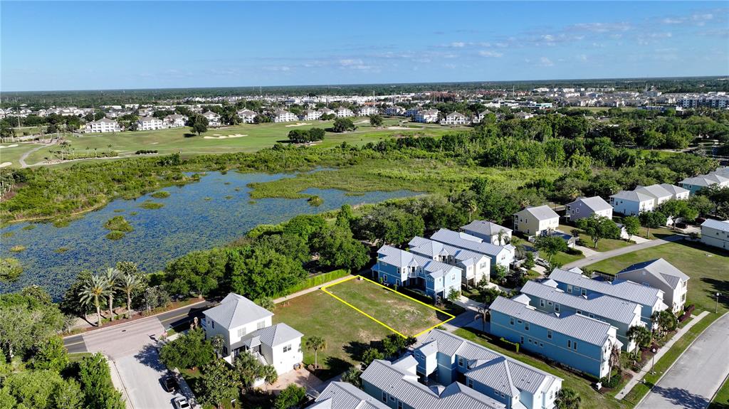 An aerial view shows a vacant residential lot outlined in yellow between existing houses — 1426 REUNION BOULEVARD, REUNION, FL