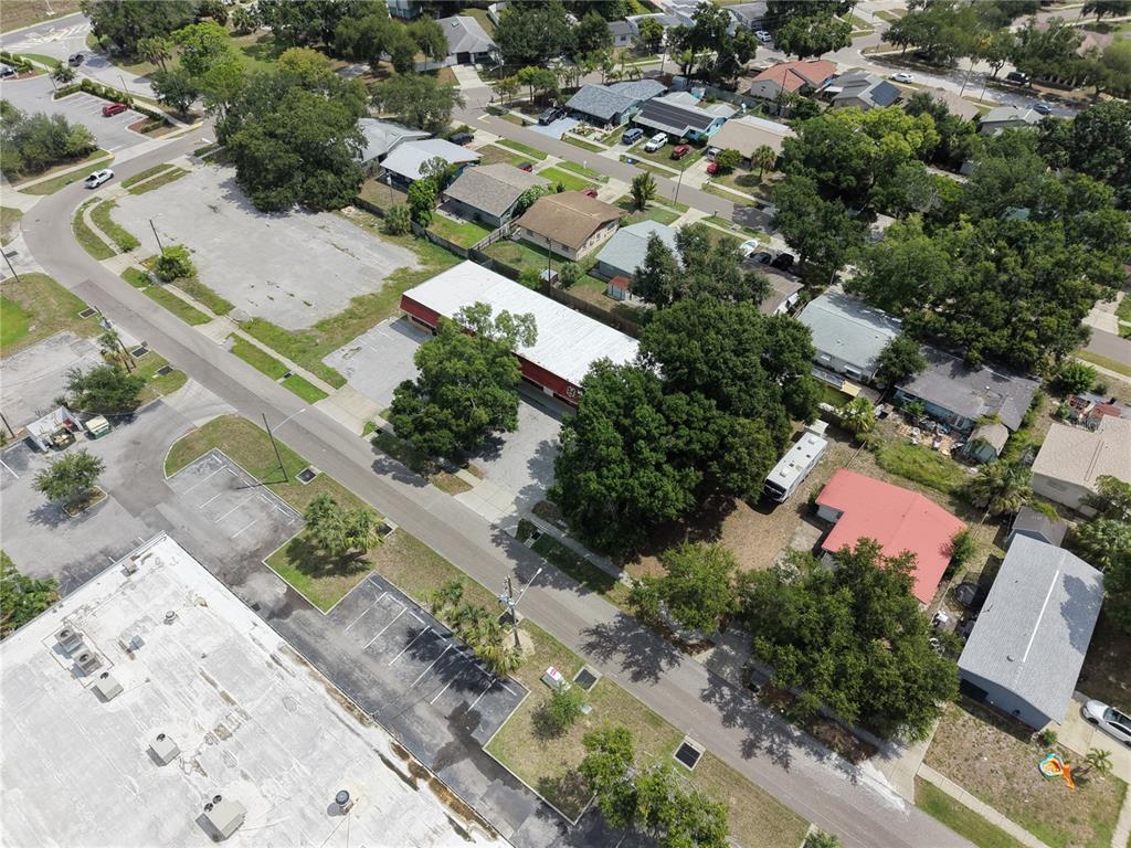 An aerial view shows a commercial building with a red roof surrounded by residential houses — 3563 CYPRESS TERRACE N, PINELLAS PARK, FL