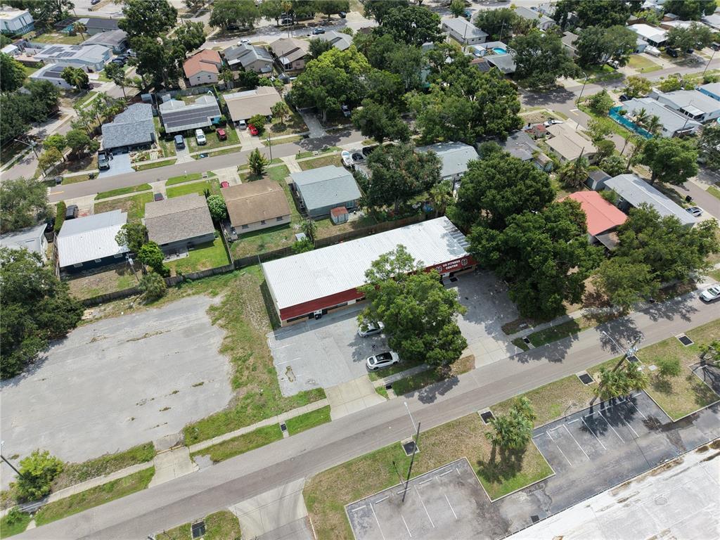 An aerial view shows a commercial building with a parking lot surrounded by residential houses — 3563 CYPRESS TERRACE N, PINELLAS PARK, FL