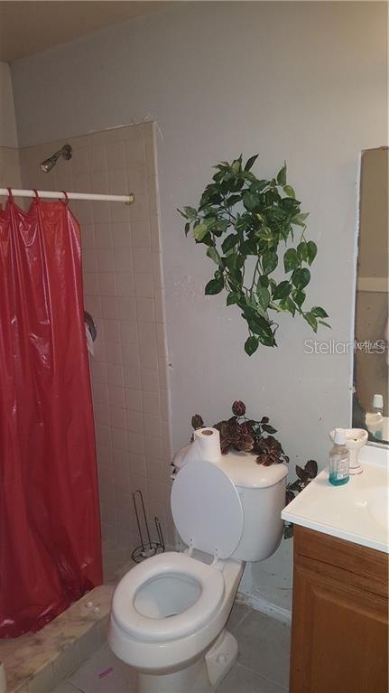 A bathroom features a red shower curtain, a white toilet, and a small vanity — 2806 SHINING WILLOW TERRACE, ORLANDO, FL