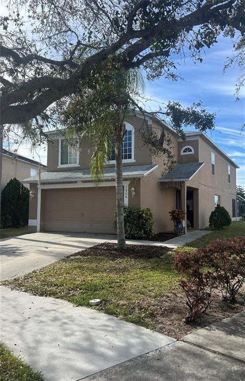 A two-story tan house with a two-car garage and a palm tree in the yard — 1906 SHERBOURNE STREET, WINTER GARDEN, FL