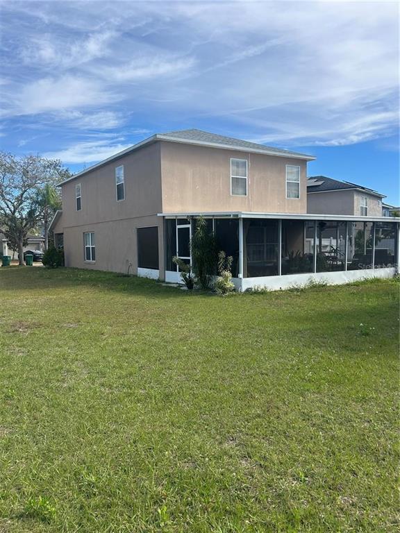 The exterior of a two-story house features a large screened-in patio and a grassy yard — 1906 SHERBOURNE STREET, WINTER GARDEN, FL