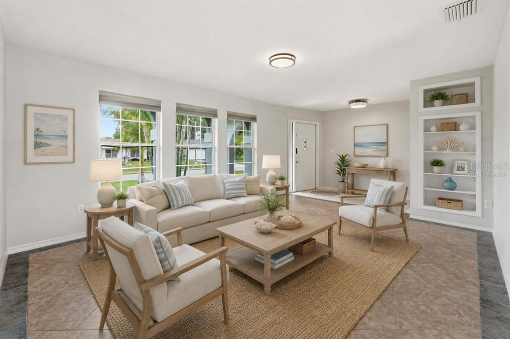 A living room with light-colored furniture, a wooden coffee table, and built-in shelving — 524 SE 8TH PLACE, CAPE CORAL, FL