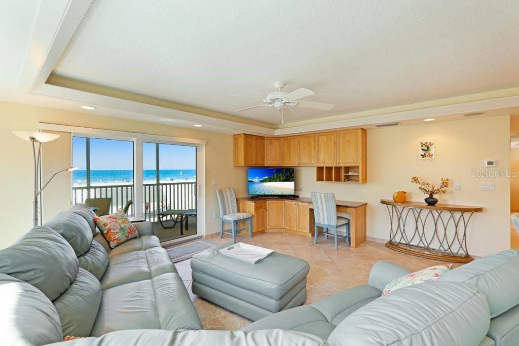 A living room with light blue leather furniture, a built-in desk, and a beach view — 6154 MIDNIGHT PASS ROAD UNIT 201, SARASOTA, FL