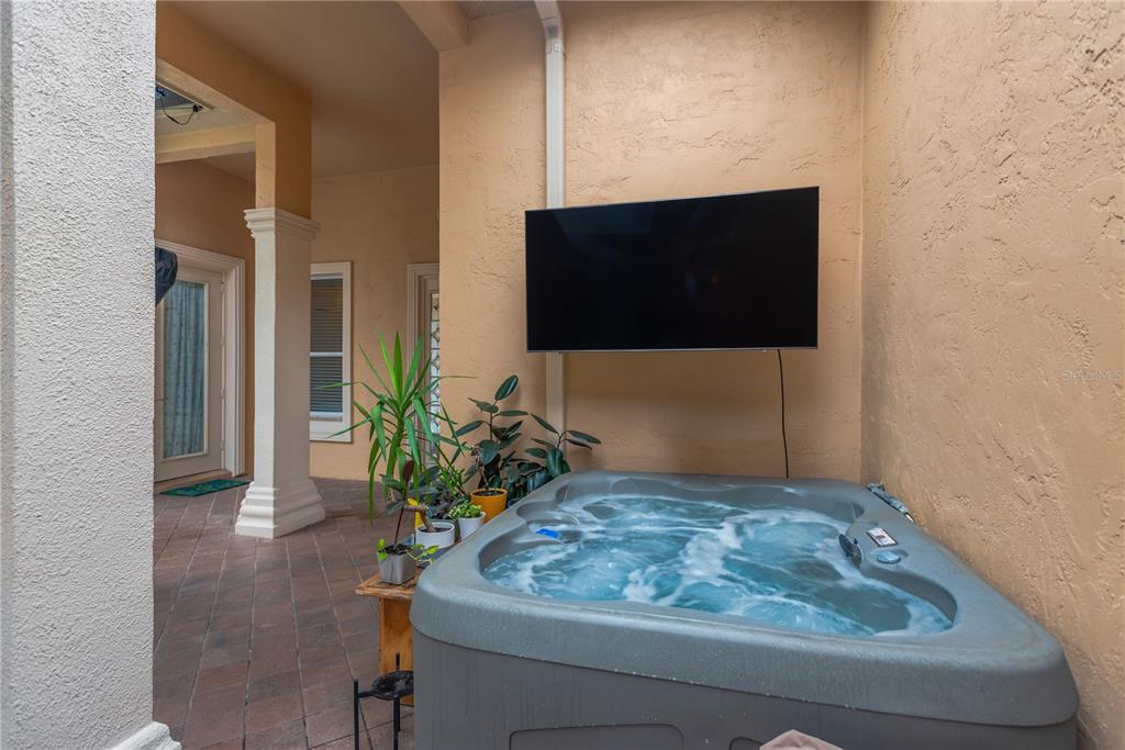 A hot tub sits on a tiled patio beneath a wall-mounted television — 1034 W SKYVIEW LANDINGS DRIVE, HERNANDO, FL