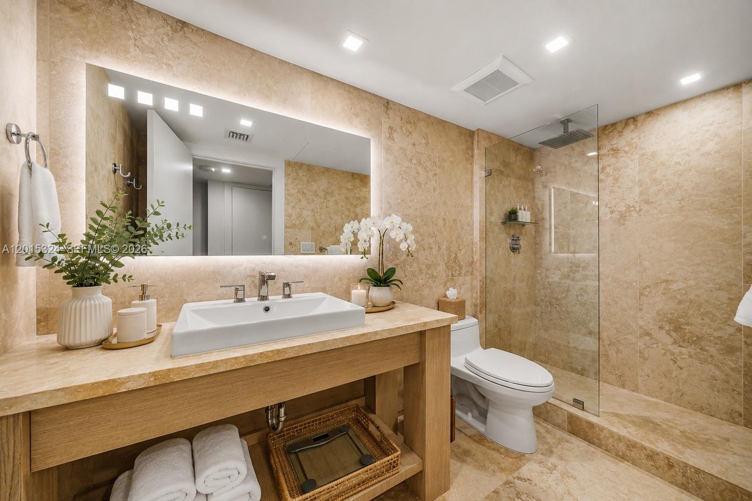A modern bathroom features a stone vanity, vessel sink, glass-enclosed shower, and beige tile walls — 2301 Collins Ave # 1128, Miami Beach FL 33139, MIAMI BEACH, FL