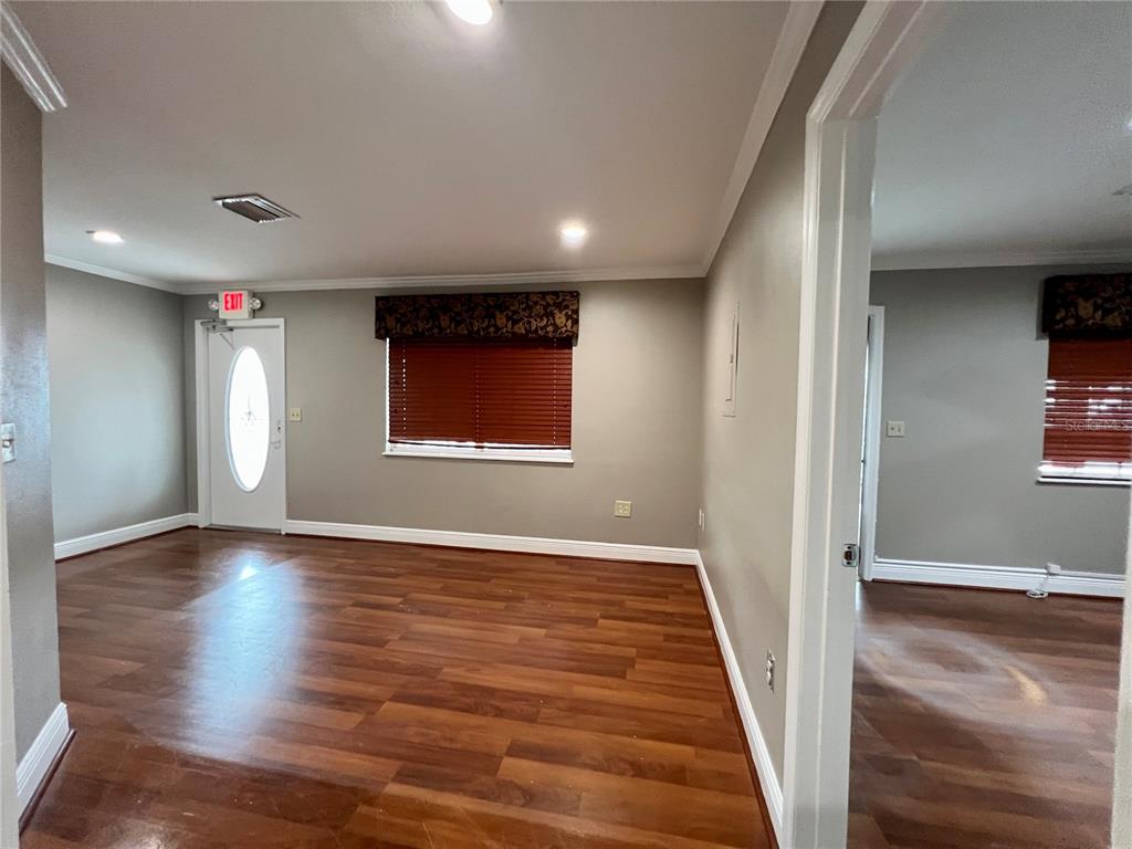 An interior view of a room with wood-look flooring, gray walls, and a white door — 3360 US HIGHWAY 441/27, FRUITLAND PARK, FL