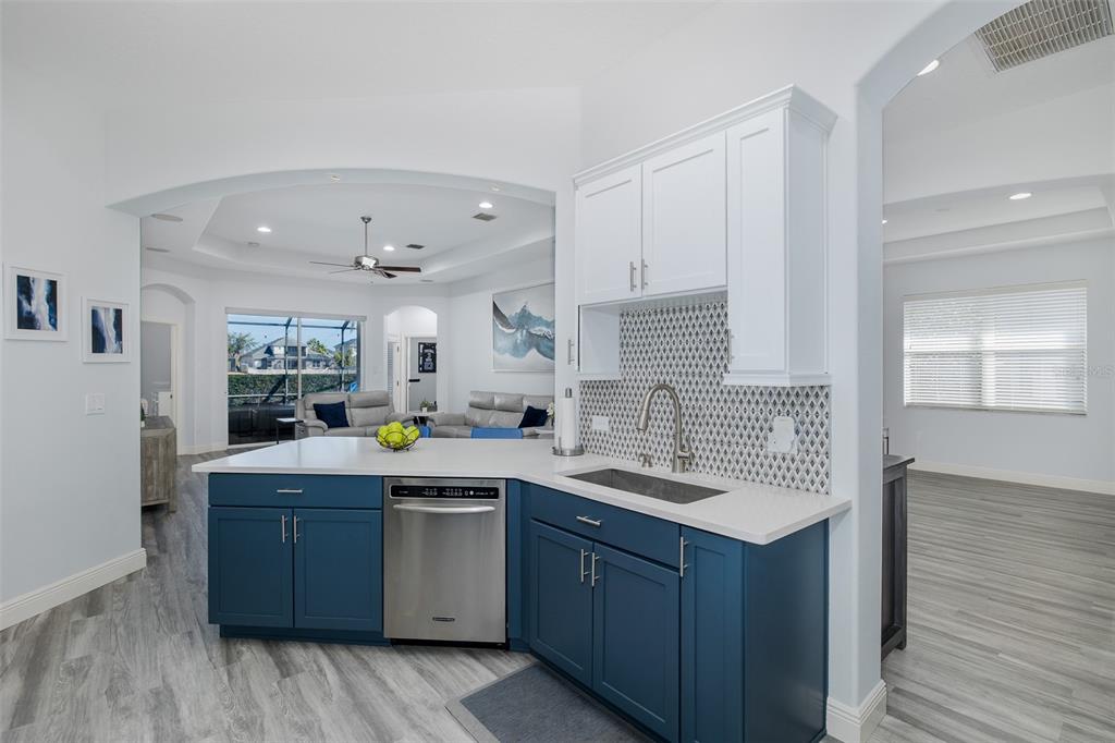 A kitchen island with blue cabinets, a stainless steel dishwasher, and a white countertop — 20301 FALLING ROCK DRIVE, LAND O LAKES, FL