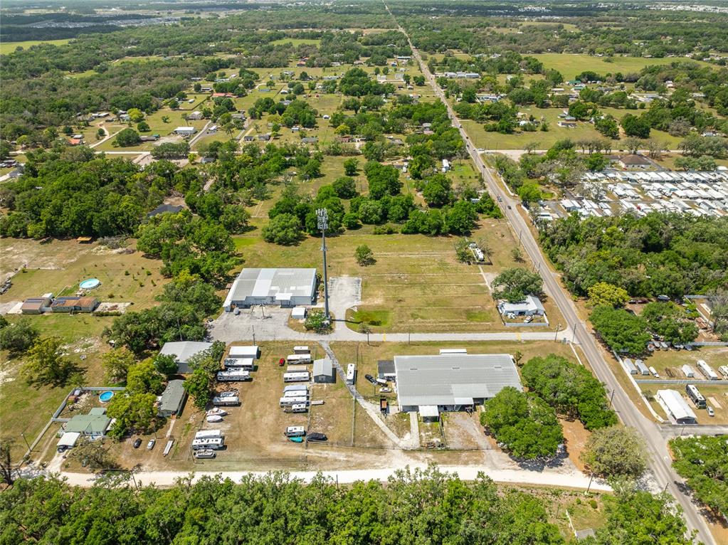 An aerial view shows a commercial property with two large buildings and several parked trailers — 37150 CHANCEY ROAD, ZEPHYRHILLS, FL