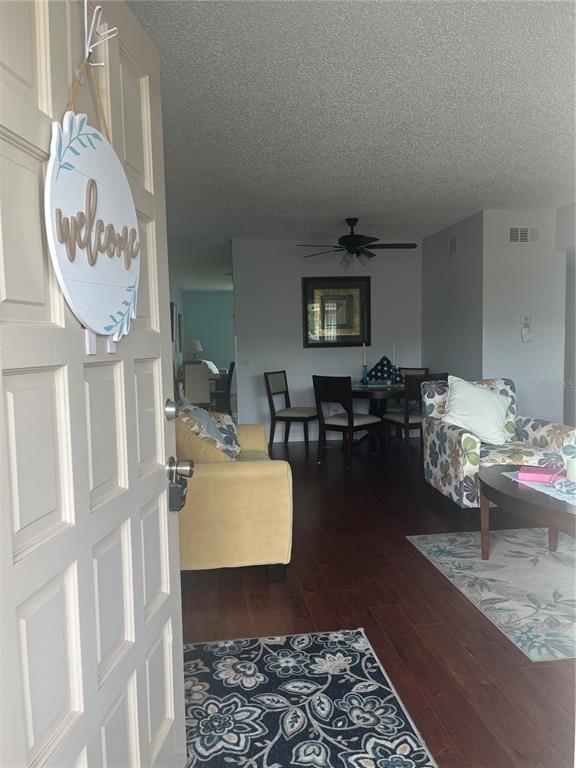 A view from an open doorway into a living and dining area with hardwood floors — 2295 BELGIAN LANE UNIT 43, CLEARWATER, FL