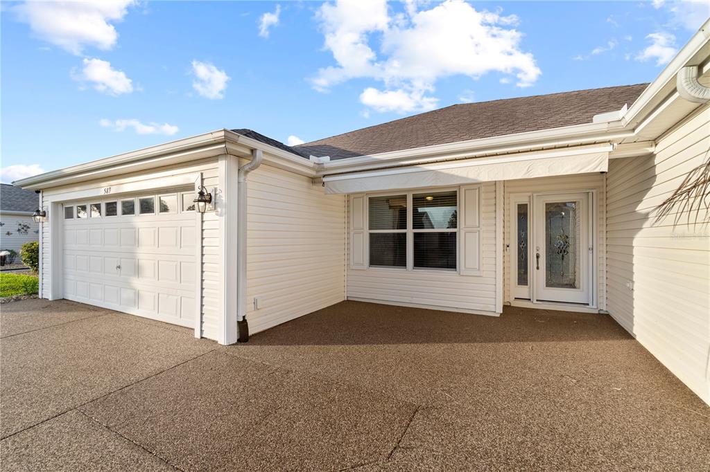The exterior of a house features a garage, a front entrance, and a paved driveway — 589 SHERWOOD STREET, THE VILLAGES, FL