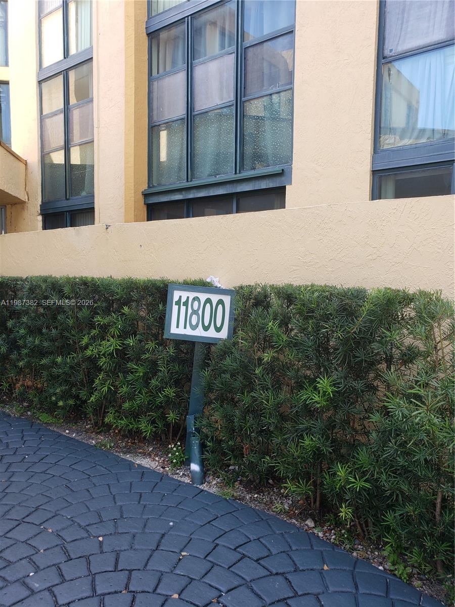 A sign with the number 11800 stands in front of a hedge and a building — 11800 SW 18th St # 4, Miami FL 33175, MIAMI, FL