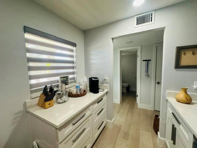 A kitchen or pantry area features white cabinets, quartz countertops, and a window with blinds — 2601 NE 3rd Court # 1050, Boynton Beach FL 33435, BOYNTON BEACH, FL