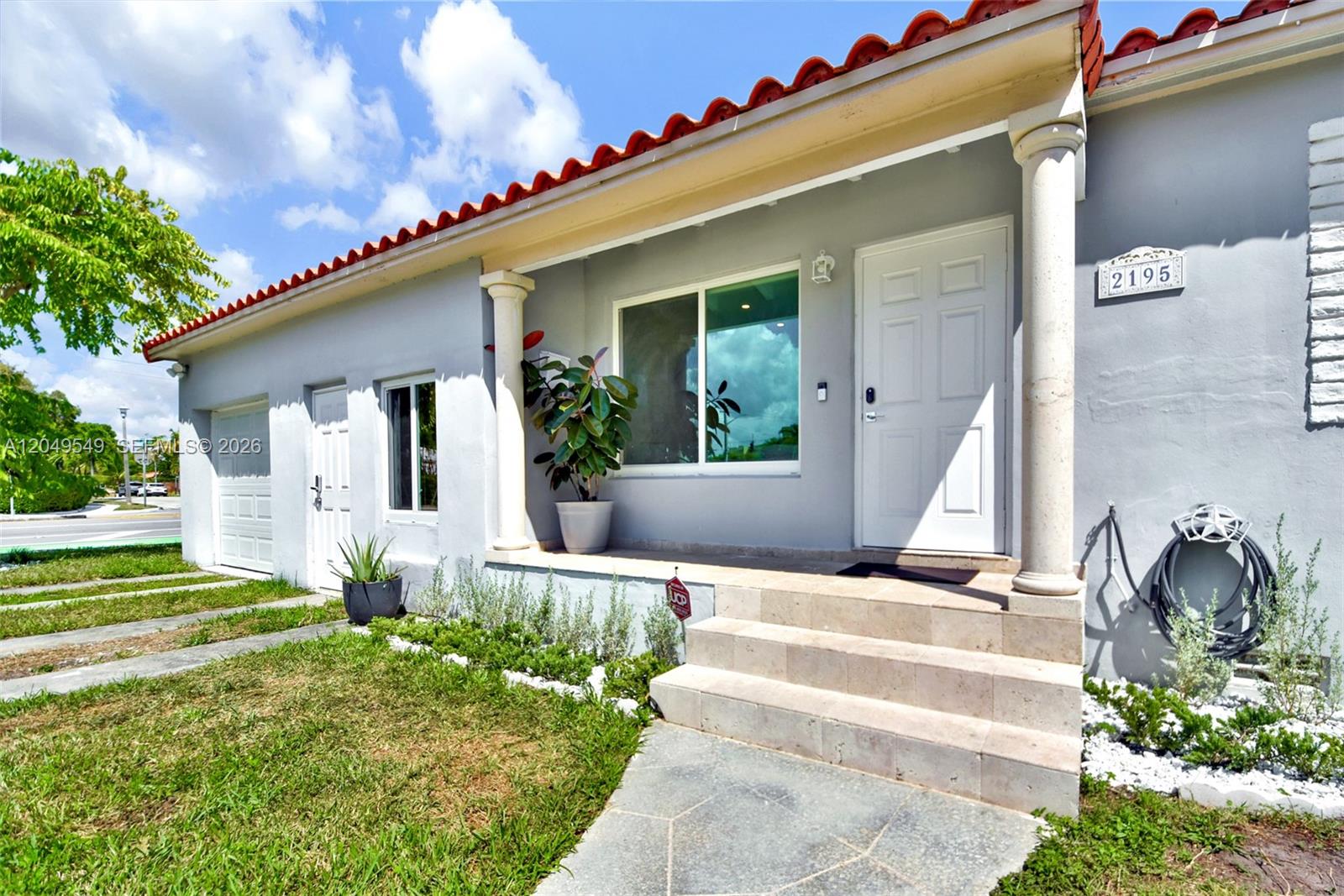 The exterior of a gray house features a tiled roof, white columns, and stone steps — 2195 SW 25th Ter, Miami FL 33133, MIAMI, FL