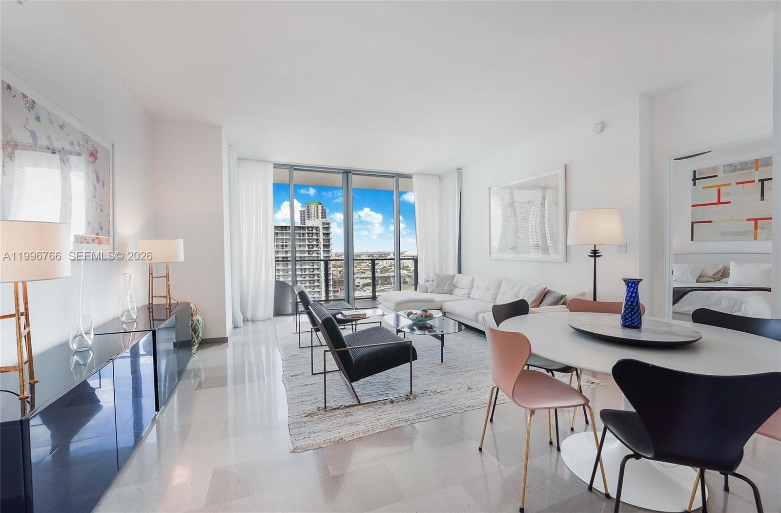 A modern living and dining area features white walls, tile floors, and floor-to-ceiling windows — 68 SE 6th St # 2104, Miami FL 33131, MIAMI, FL
