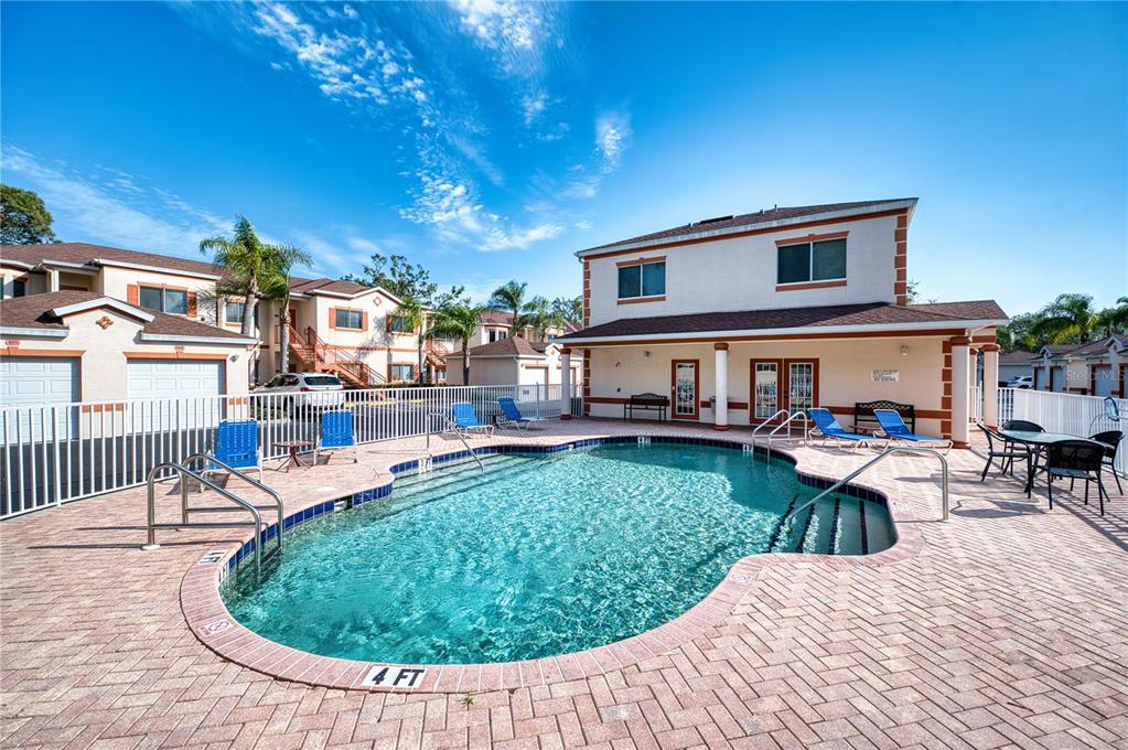 A kitchen with white cabinets, granite countertops, a double sink, and an adjacent living area — 3980 MEDITERRANEA CIRCLE UNIT 522, SARASOTA, FL