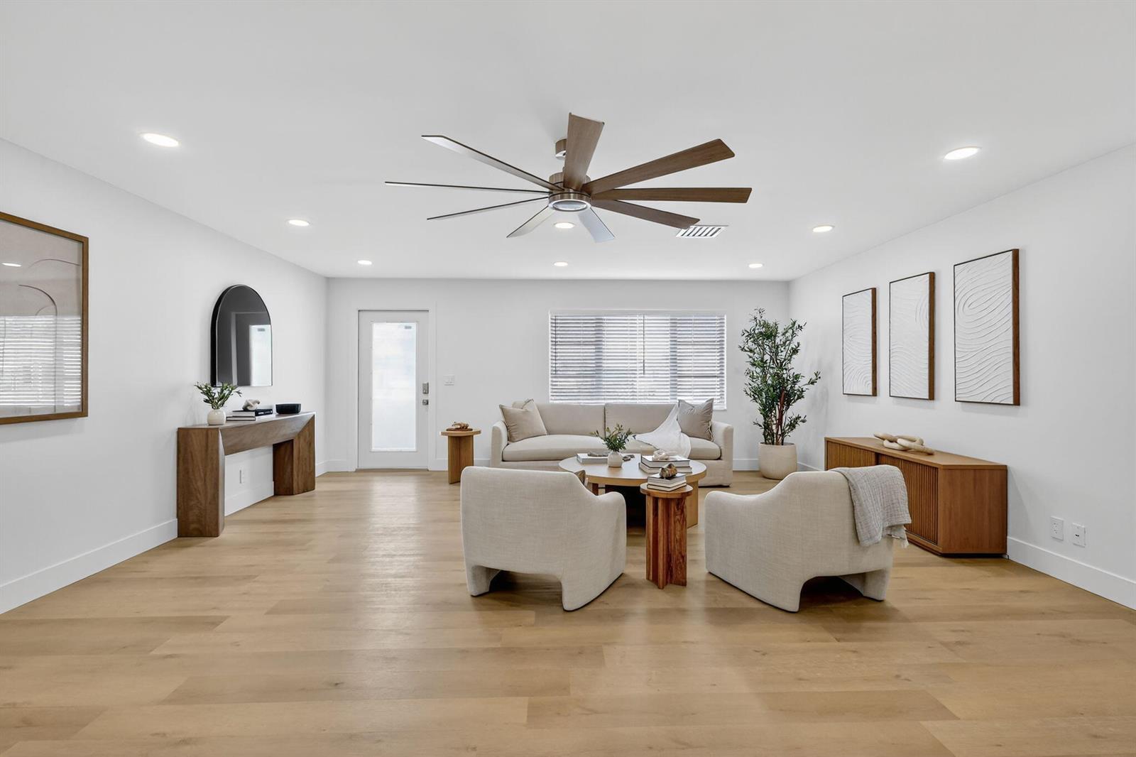 A bright living room features light wood floors, a neutral sofa, two armchairs, and a ceiling fan — 2206 SW 20th Way, Boynton Beach FL 33426, BOYNTON BEACH, FL