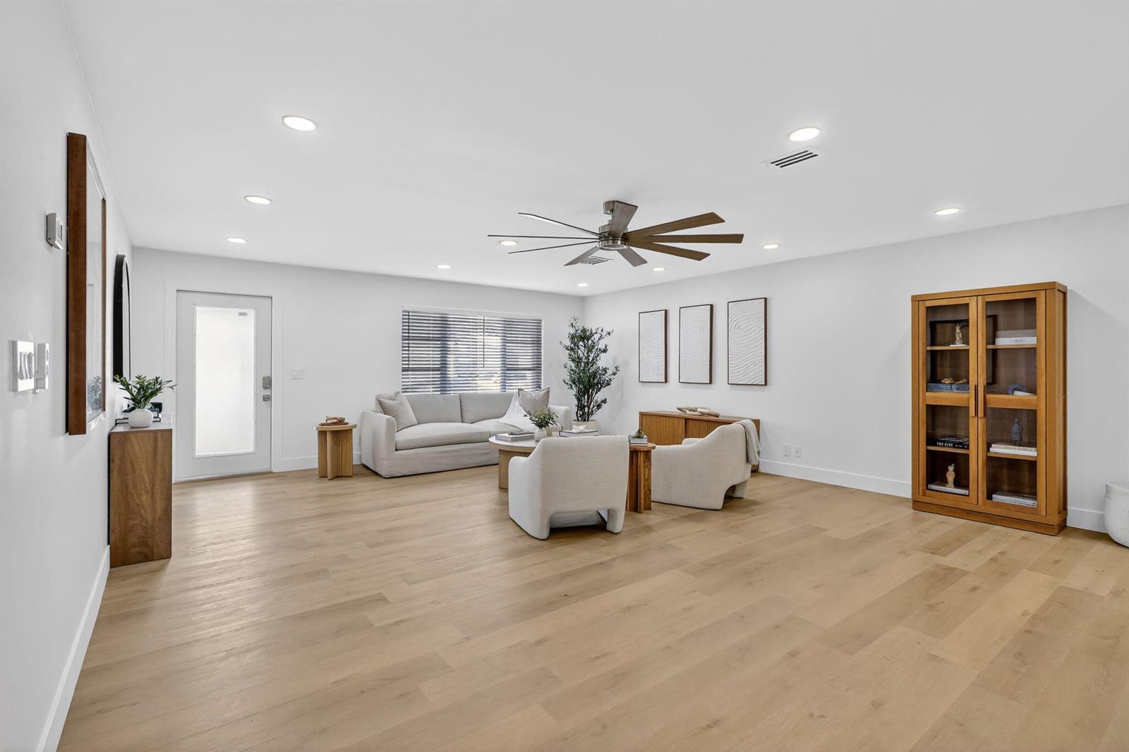 A bright living room features light wood flooring, a ceiling fan, and neutral-toned furniture — 2206 SW 20th Way, Boynton Beach FL 33426, BOYNTON BEACH, FL
