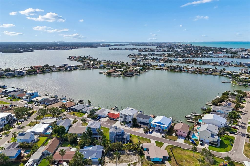 An aerial view shows waterfront houses along a bay with docks and boats — 211 176TH TERRACE DRIVE E, REDINGTON SHORES, FL