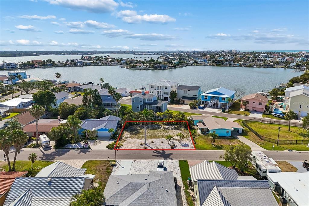 An aerial view shows a vacant residential lot outlined in red near a waterfront neighborhood — 211 176TH TERRACE DRIVE E, REDINGTON SHORES, FL