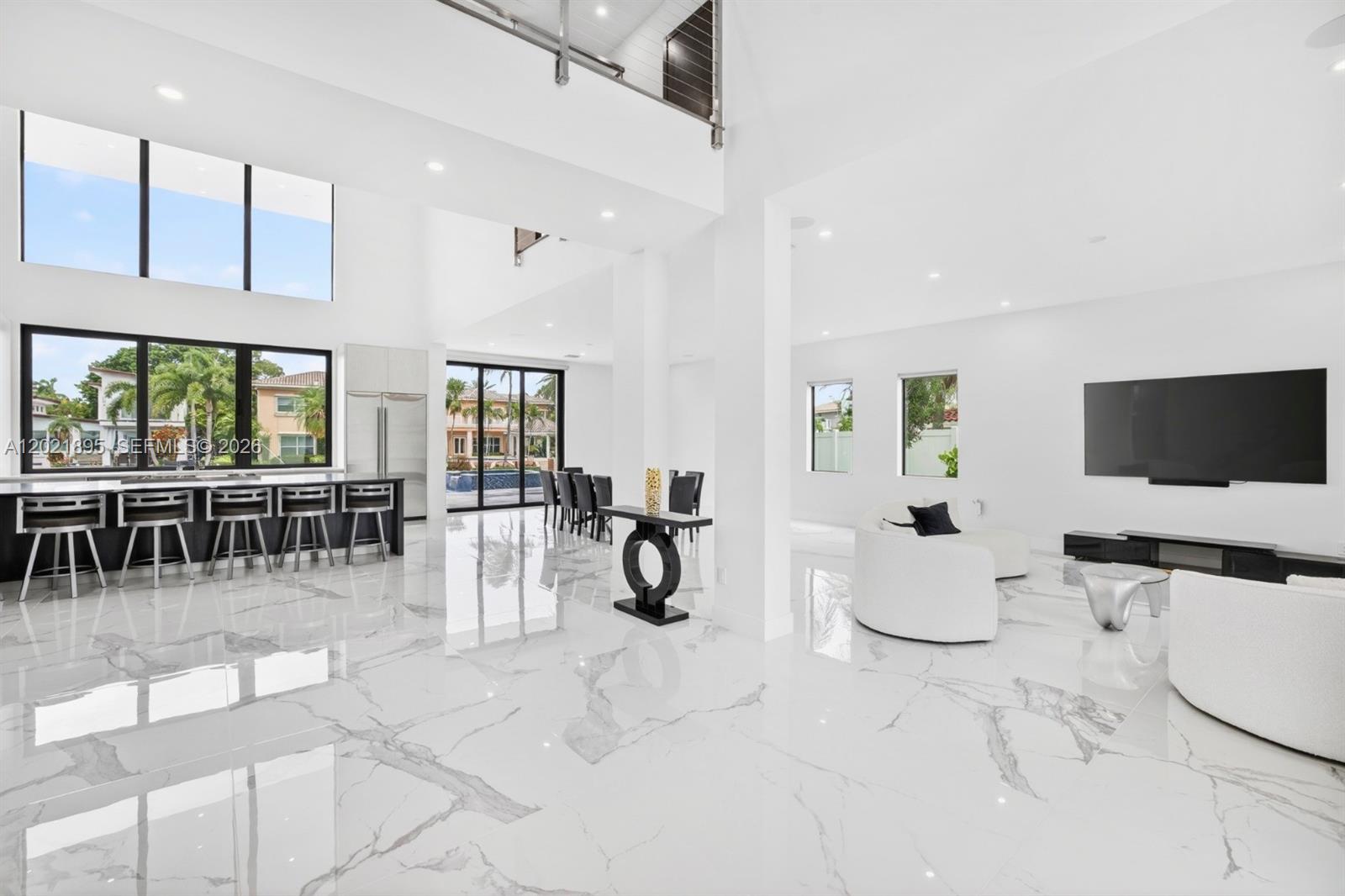 A spacious, modern living area features white marble floors, high ceilings, and a kitchen island — 2751 NE 22nd Ct, Pompano Beach FL 33062, POMPANO BEACH, FL