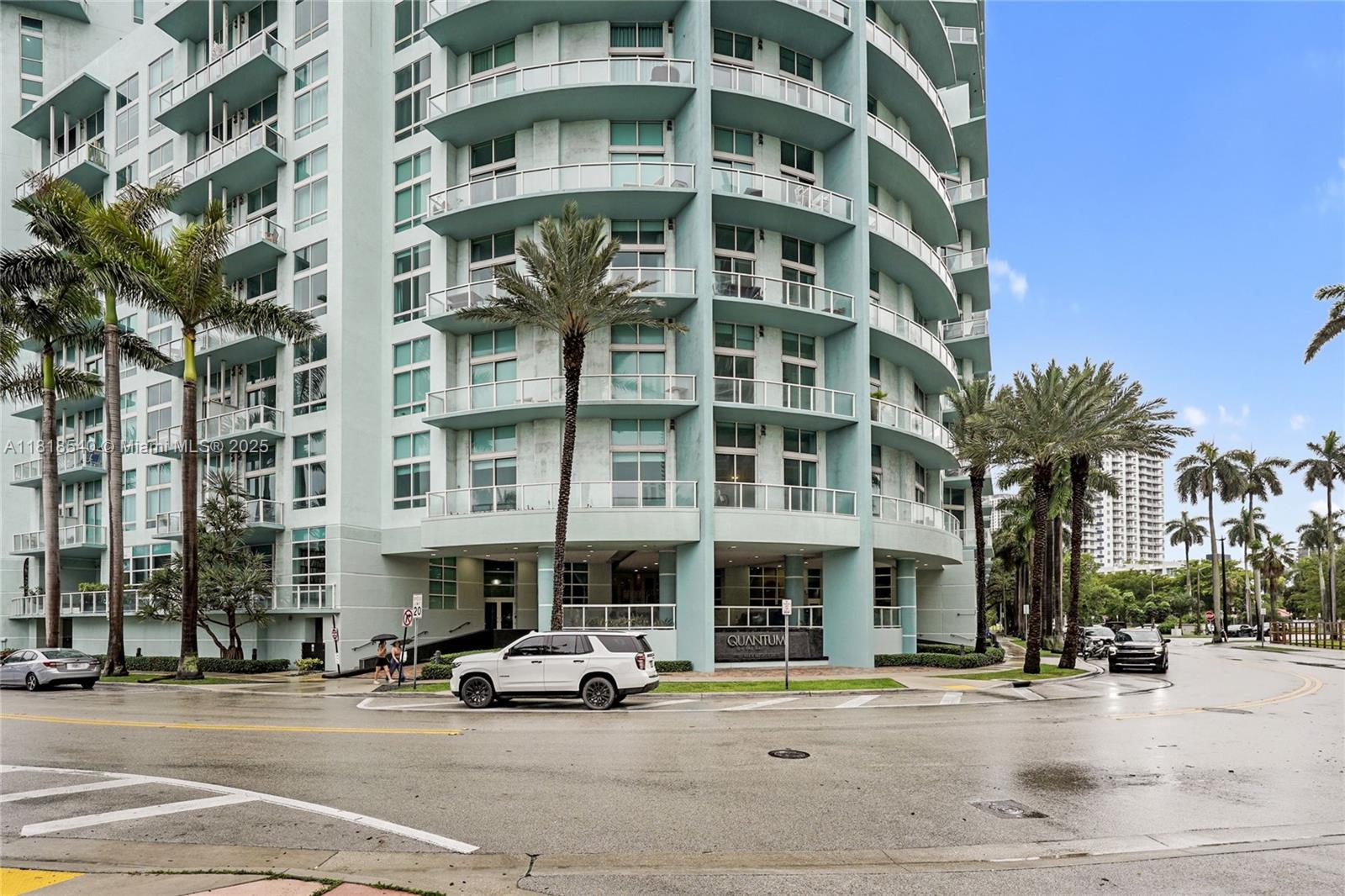 A light blue high-rise apartment building with curved balconies stands near a street intersection — 1900 N Bayshore Dr # 1411, Miami FL 33132, MIAMI, FL