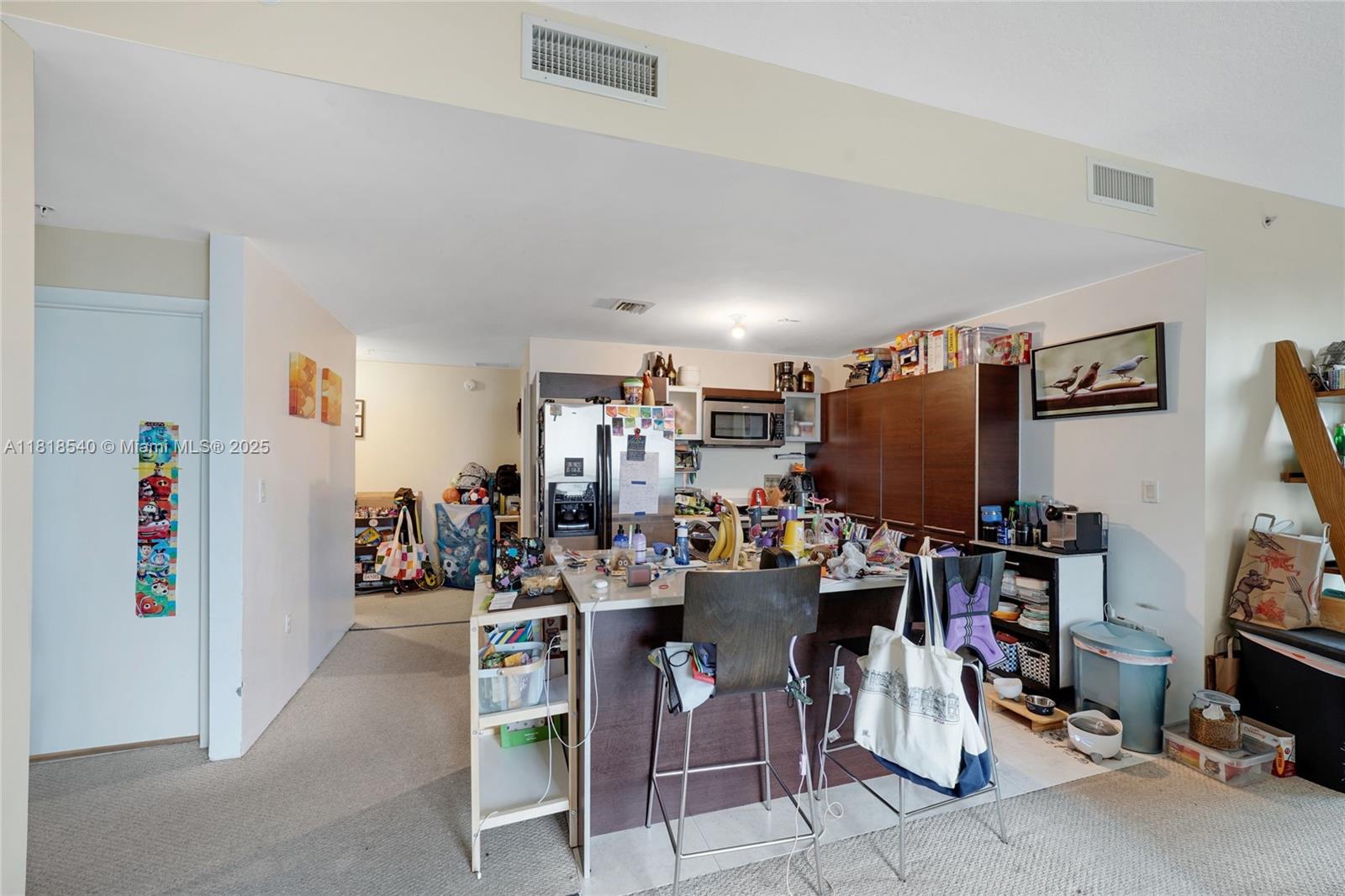 A kitchen with a central island, dark wood cabinetry, and a cluttered countertop — 1900 N Bayshore Dr # 1411, Miami FL 33132, MIAMI, FL