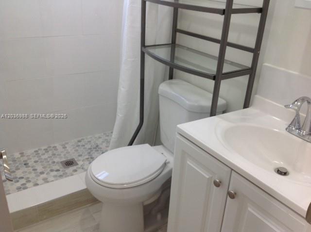 A bathroom features a white vanity, a toilet with a metal shelf, and a tiled shower — 3350 SW 3rd St, Miami FL 33135, MIAMI, FL