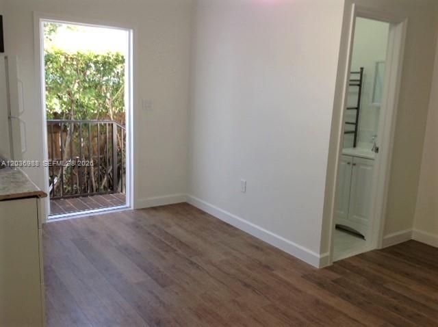 A room with wood-look flooring, a glass door to a balcony, and an adjacent bathroom — 3350 SW 3rd St, Miami FL 33135, MIAMI, FL
