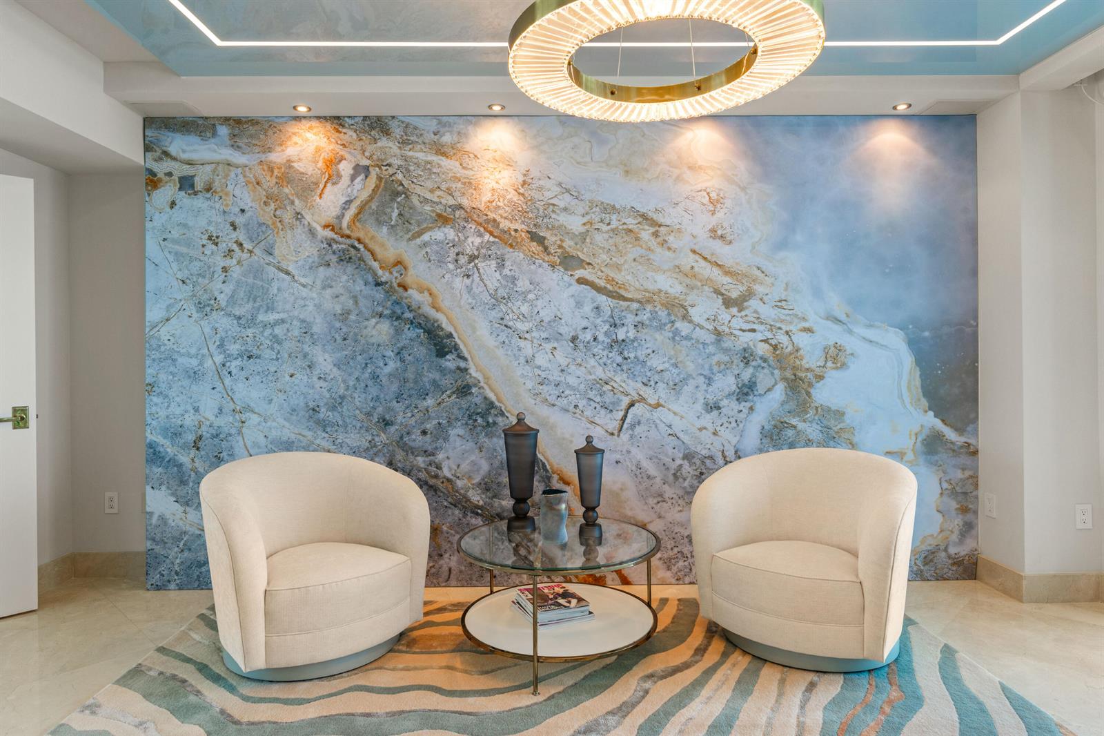 Two cream armchairs sit before a large marble accent wall and a glass coffee table — 3101 S Ocean Drive # 901, Hollywood FL 33019, HOLLYWOOD, FL