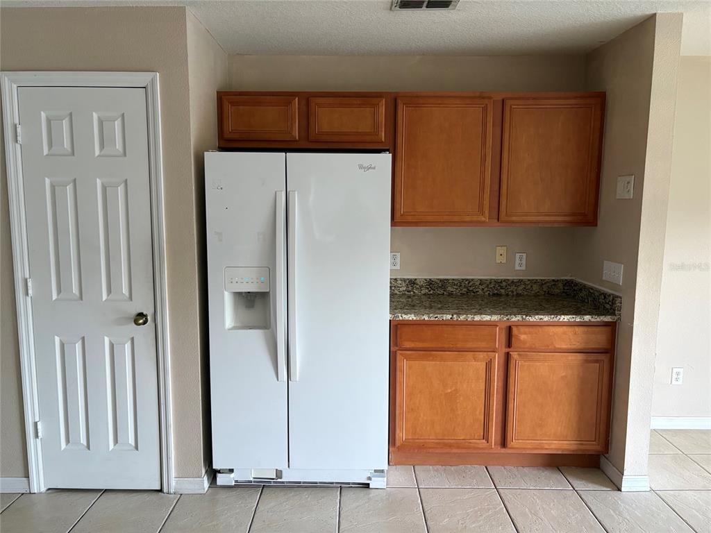 An empty room features light brown walls, wood-look flooring, and a single window with blinds — 15628 PERDIDO DRIVE, ORLANDO, FL