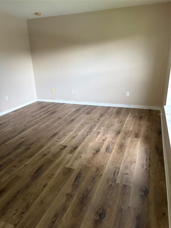 An empty room with tan walls and light-colored wood-look flooring — 15628 PERDIDO DRIVE, ORLANDO, FL