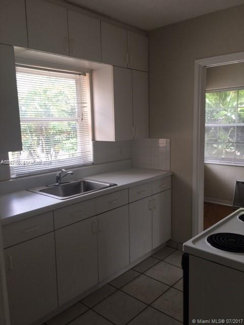 A kitchen features white cabinets, a stainless steel sink, and tiled floors — 1002 SW 37th Ave # 3, Coral Gables FL 33127, CORAL GABLES, FL