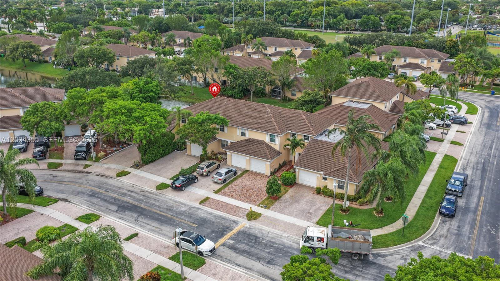 An aerial view shows a residential neighborhood with townhouses, paved driveways, and parked cars — 8964 NW 53rd Ct, Sunrise FL 33351, SUNRISE, FL