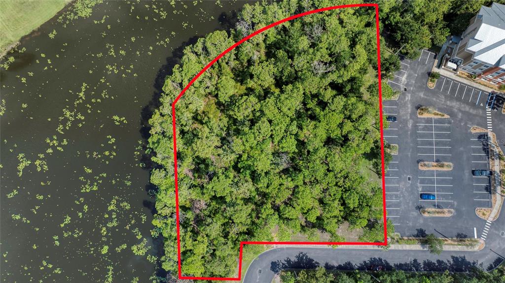 This aerial view shows a wooded lot outlined in red next to a parking lot — xxx GARDEN STREET N, PALM COAST, FL