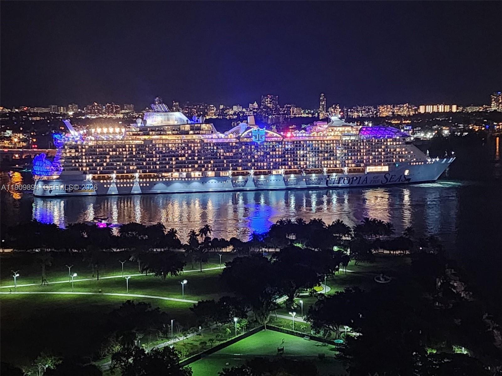 A large cruise ship is illuminated at night on the water near a park — 900 Biscayne Blvd # 2602, Miami FL 33132, MIAMI, FL