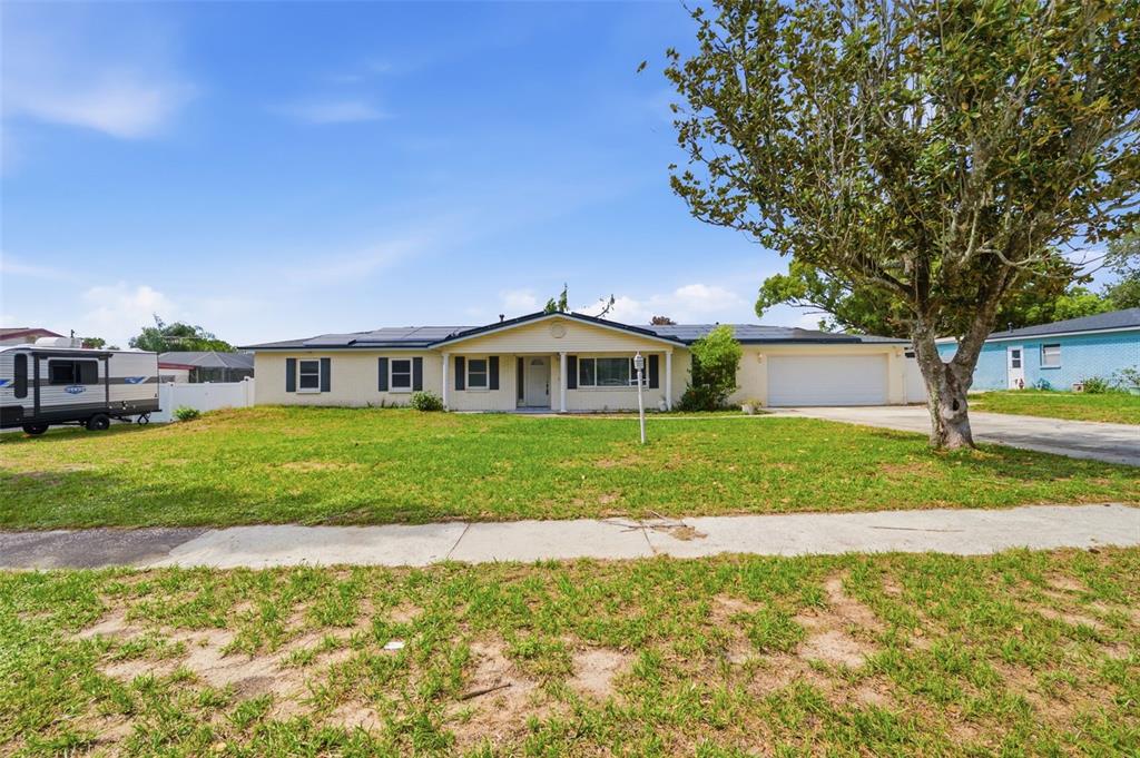 A single-story house with a white garage and solar panels on the roof — 1606 LARK LANE, BRANDON, FL