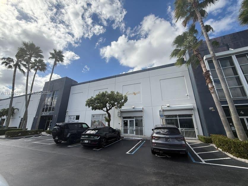 A low-rise commercial building with two parked cars in front under a cloudy sky — 7620 NW 25th St # 5, Miami FL 33122, MIAMI, FL