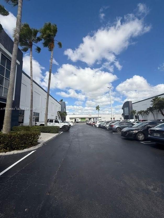 A parking lot sits between two modern commercial buildings under a bright, cloudy sky — 7620 NW 25th St # 5, Miami FL 33122, MIAMI, FL