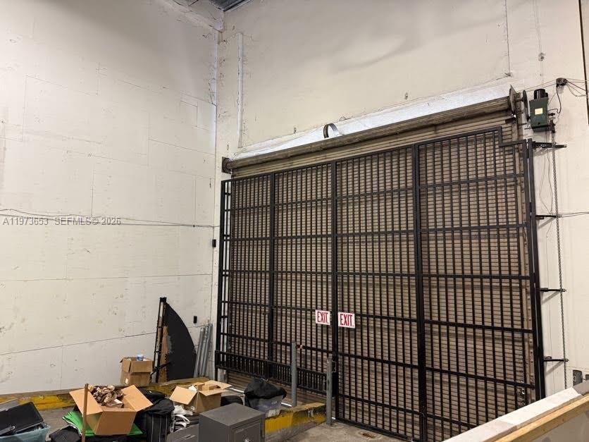 A large industrial space features a high ceiling, white block walls, and a metal security gate — 7620 NW 25th St # 5, Miami FL 33122, MIAMI, FL